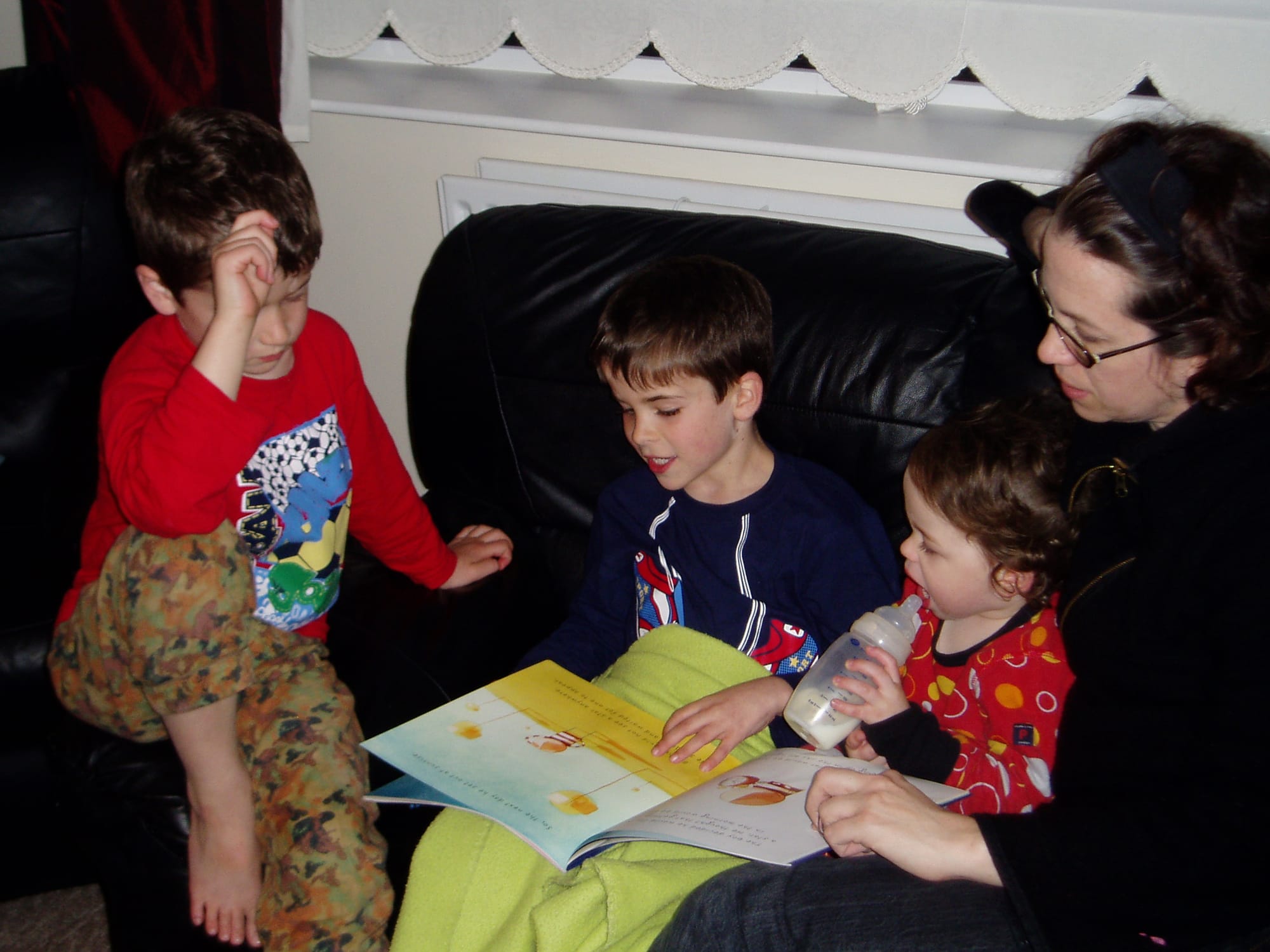 Picture of children all listening to a book being read.
